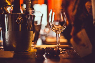 wine tasting: an empty glass stands on the tasting table next to brochures, champagne corks and silver buckets in which the wines are cooled.