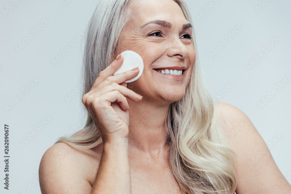 Wall mural Woman cleansing her face