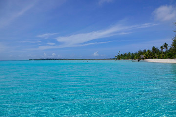 Fototapeta na wymiar AERIAL: Breathtaking view of calm turquoise ocean surrounding tropical island.