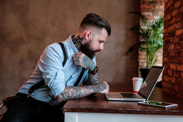 Portrait of bearded man with tattoes on his arms