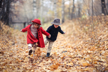 boy and girl in hats walk in park, autumn mood