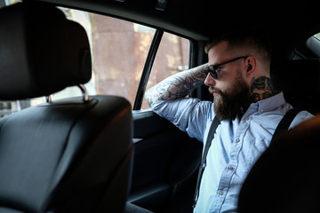 Portrait of bearded man with tattooes on his arms