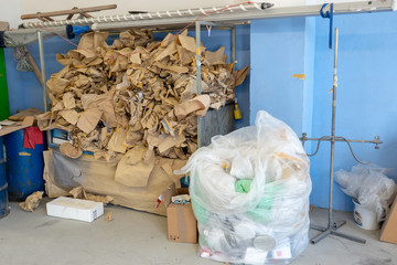 In the corner of a workshop, a mountain of garbage is piling up