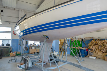 a sailing ship stands in a paint shop to be repainted