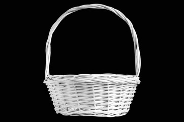 Wicker white basket with handle on black background. Isolated object. Basket for gifts, flowers and fruit.