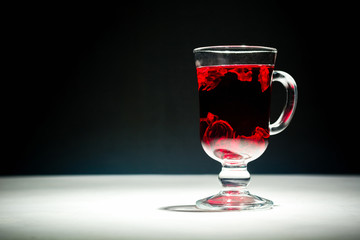 Transparent glass Cup with hot red tea from hibiscus or hibiscus.