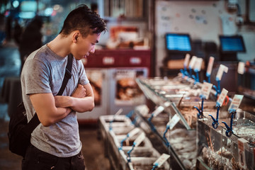 Young asian man is choosing products at market