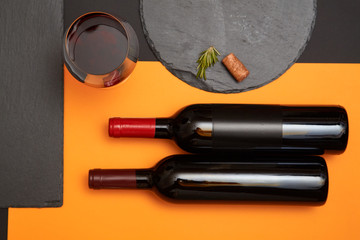 Geometry composition of wine cork on black slate board with glass of wine and bottle on colorful...