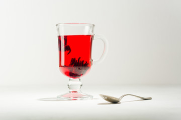 Transparent glass Cup with hot red tea from hibiscus or hibiscus.
