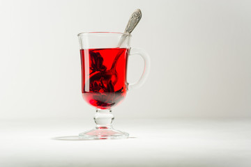 Transparent glass Cup with hot red tea from hibiscus or hibiscus.