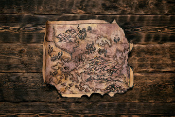 Old map on a adventurer table background. Treasure hunt concept.