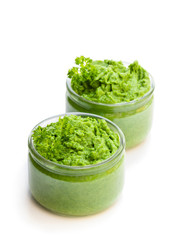 Green puree in glass jars isolated on white
