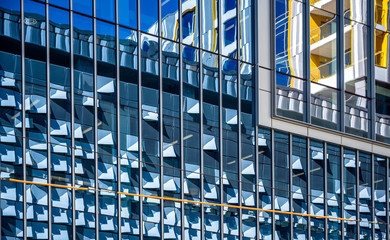 High-rise modern building with glass exterior that reflects the decoration of the opposite...