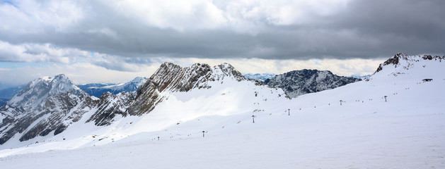 ski lift  in the skiing area in the snow covered mountains of the Bavarian alps on a cloudy day, ...