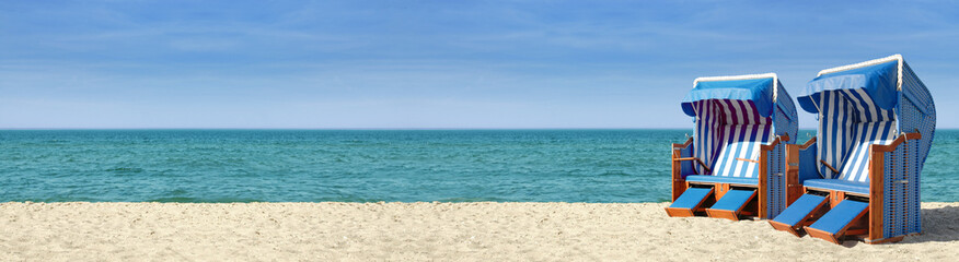 Panorama de plage avec deux chaises de plage bleues et blanches