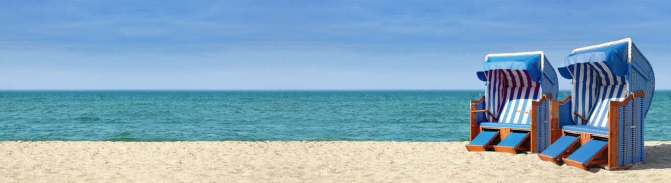 Strandpanorama mit zwei blauweissen Strandk&ouml;rben