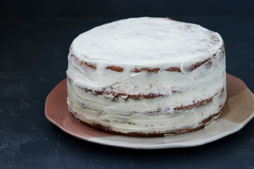 Preparing a biscuit cake for decorating cream on a dark background