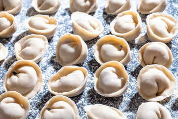 Raw dumplings on table sprinkled with flour