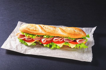 Big submarine sandwich with ham, cheese and salad