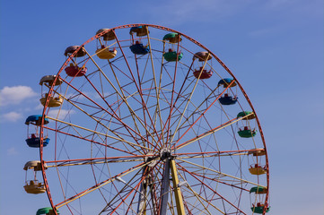 Ferris wheel in the park against blue sky.