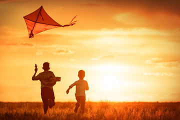 Children with a kite at sunset