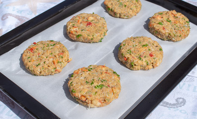 Best fish cakes raw uncooked on  baking tray. .Row of crab patties.