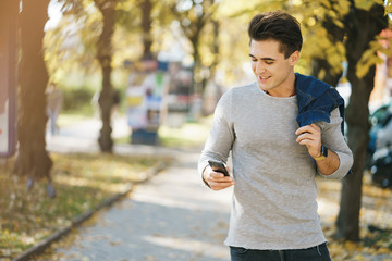 Fototapeta na wymiar stylish man using his phone while walking through the city by himself