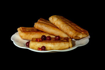 fried pancakes. stuffed pancakes. wrapped pancakes on a white plate with berries