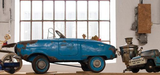 Old vintage toy cars with doll. Bright window in background.