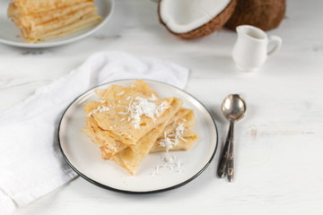 Morning, breakfast - traditional russian blini pancakes, french crepes, fresh coconut, milk bottle, white ceramic pitcher