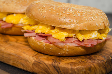 Breakfast sandwich bagel with egg and bacon, close-up view.
