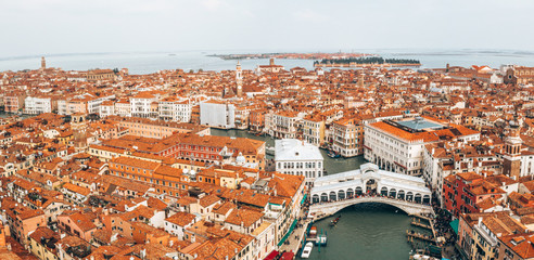 Aerial panoramic view of famous Canal Grande and famous Rialto Bridge at sunset in Venice, Italy.