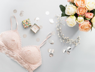 Top view pink lace lingerie. Beauty blog concept. Woman fashion accessories, lingerie, bouquet of roses, ring in box. Flat lay, magazines, social media. Bacground with confetti