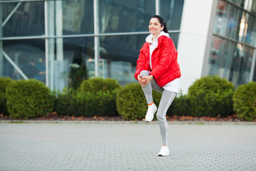 Fitness girl. Young sports woman stretching in the modern city. Healthy lifestyle in the big city