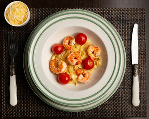 Spaghetti shrimp in white dish, top view noodles spicy with seafood on black background