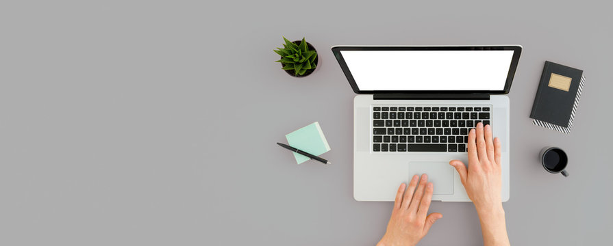 Man working on laptop in cozy, minimal workspace. Top view and blank screen mockup.
