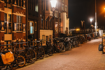Night cozy Amsterdam streets with bike parking and warm light