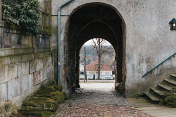 Fototapeta na wymiar Medieval european castle arch with view on street
