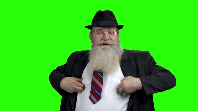 Funny old man jokingly playing with his nipples. Cheerful senior bearded man in hat having fun. Chroma Key background.