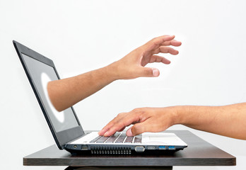Abstract image of the hacker's hand reach through a laptop screen during business man on typing....