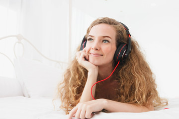 Naklejka premium The sleeping young woman listening to music, happily.