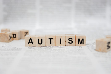 Autism Word Written In Wooden Cube - Newspaper
