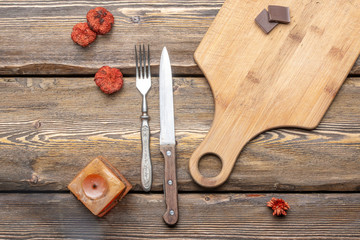 utensils with square candle and vintage cutlery on wooden background, top view 