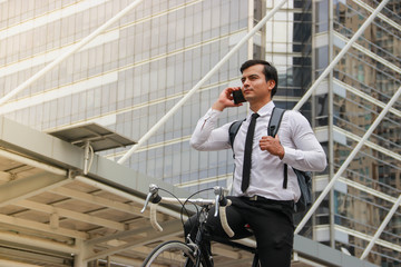 As a successful young businessman in dark hair, to work on his bicycle in the morning, Check the weather through the smartphone.