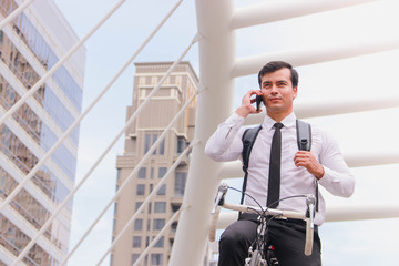 As a successful young businessman in dark hair, to work on his bicycle in the morning, Check the weather through the smartphone.