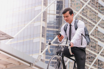 Fototapeta na wymiar As a successful young businessman in dark hair, to work on his bicycle in the morning, Check the weather through the smartphone.