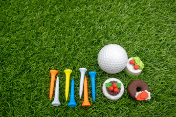 Naklejka premium Multicolour tees are on green grass for golfer 's birthday with cakes
