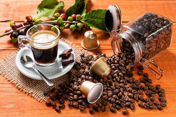 Glass of clear glass of hot coffee on wooden table. Orange wood pinus.