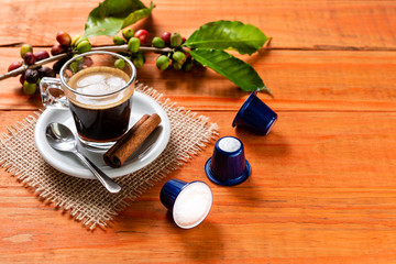 Glass of clear glass of hot coffee on wooden table. Orange wood pinus.