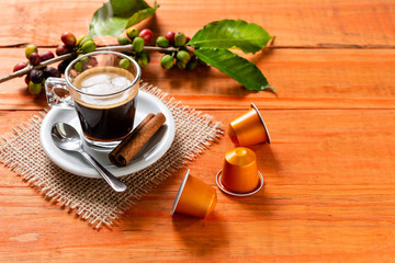 Glass of clear glass of hot coffee on wooden table. Orange wood pinus.